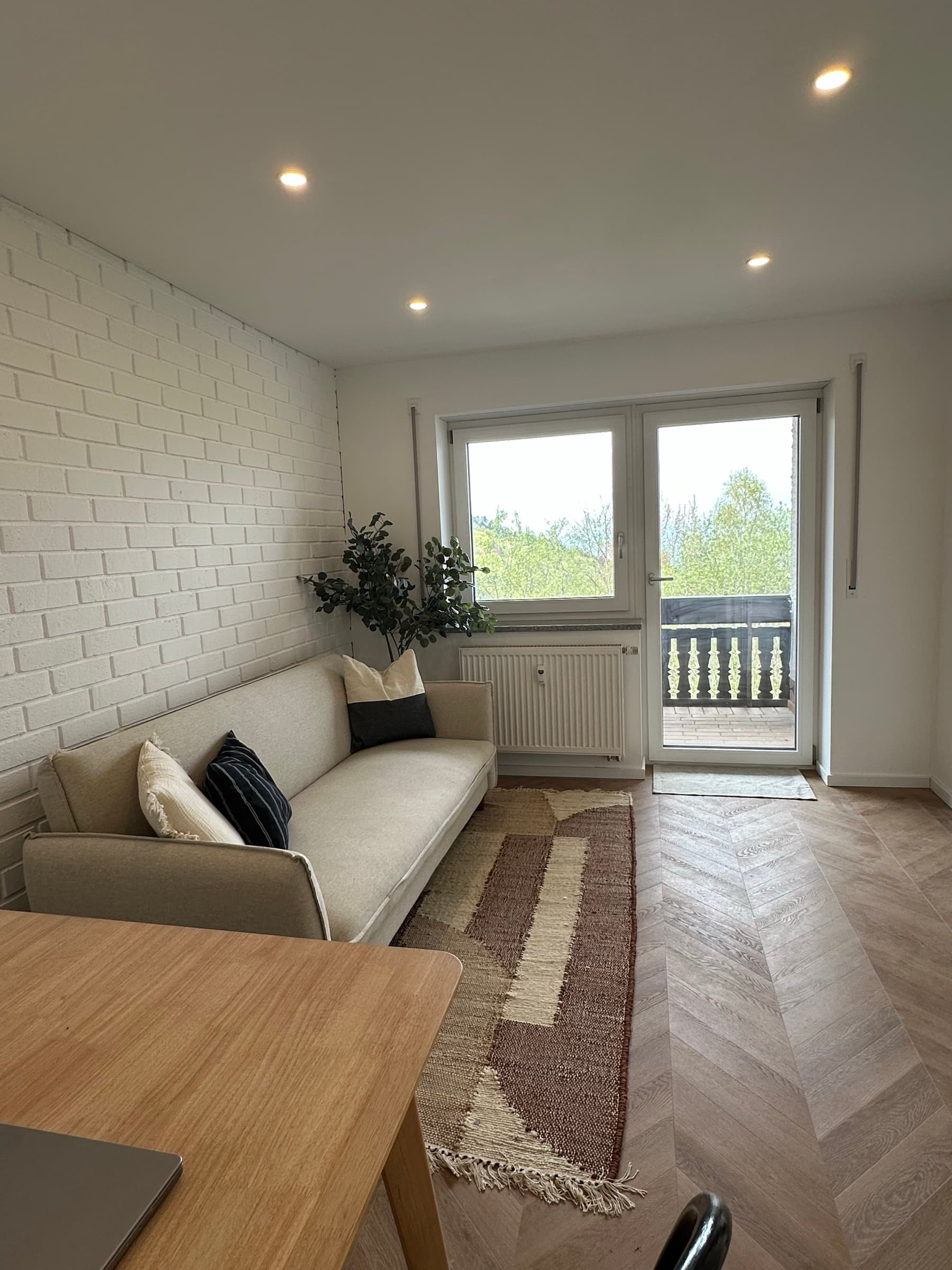 Apartment B7 – Sofabereich mit Backsteinwand