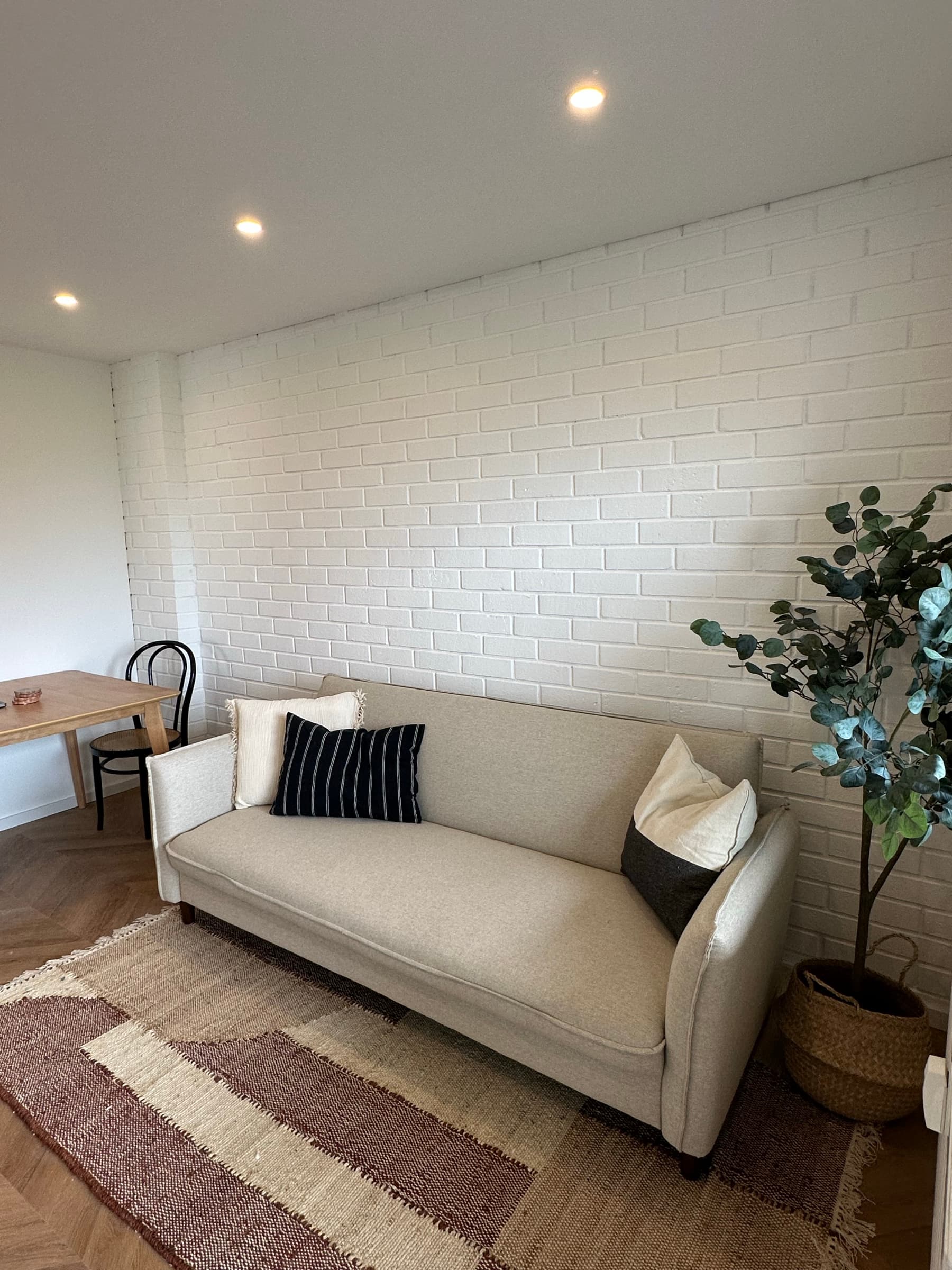 Apartment B7 – Sofabereich mit Backsteinwand