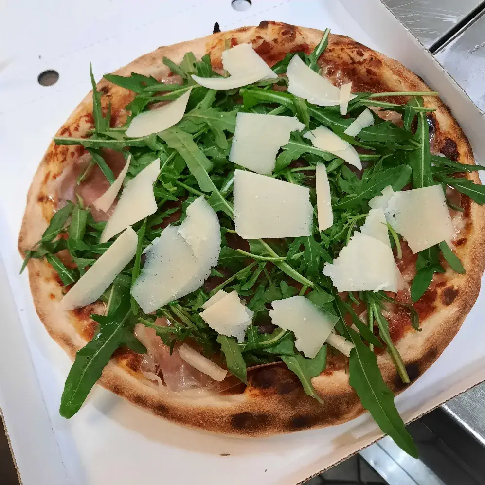 Hausgemachte Pizza mit Rucola und Parmesan im Gasthaus Lohner